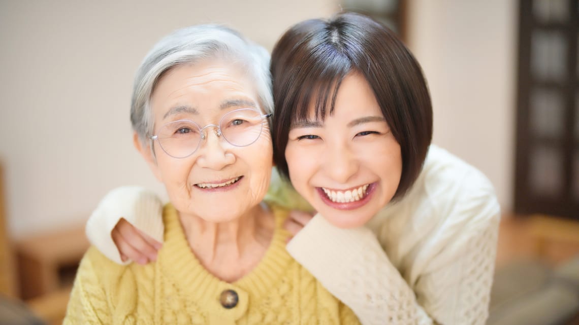 祖母に寄り添って笑顔を見せる孫のイメージ