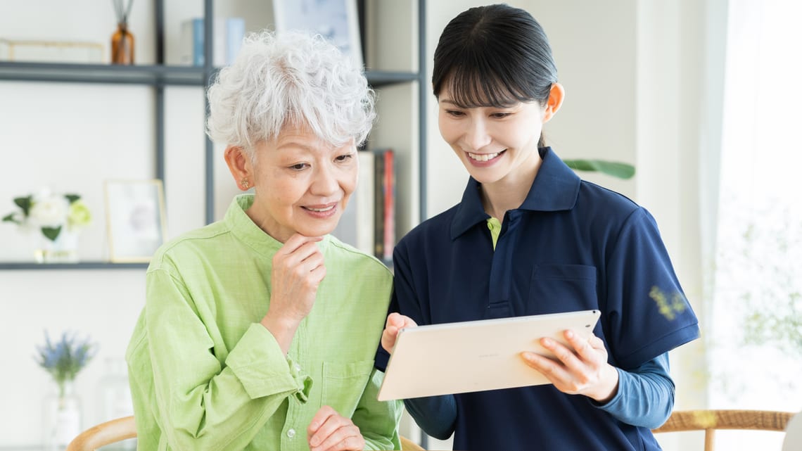職員から説明を受ける高齢の女性のイメージ