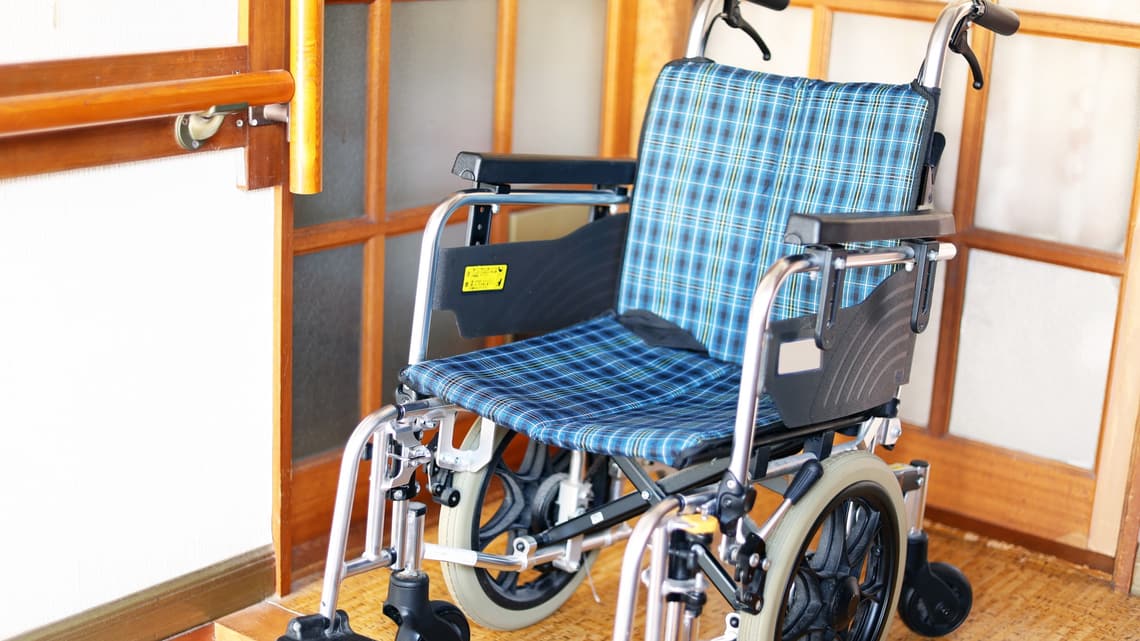 家の玄関に置かれた、折りたたみの車いすのイメージ