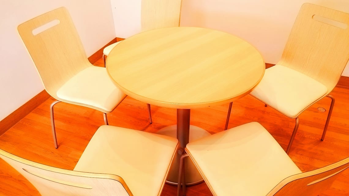 明るい部屋に置かれた、丸いテーブルと椅子のイメージ
