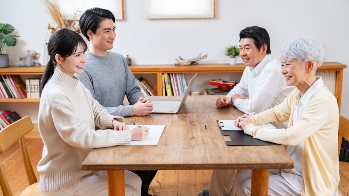 テーブルを囲んで話し合う親子のイメージ