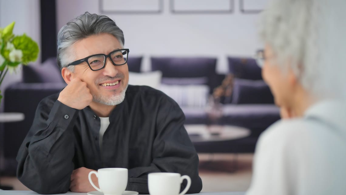 コーヒーを飲みながら話す高齢のご夫婦のイメージ