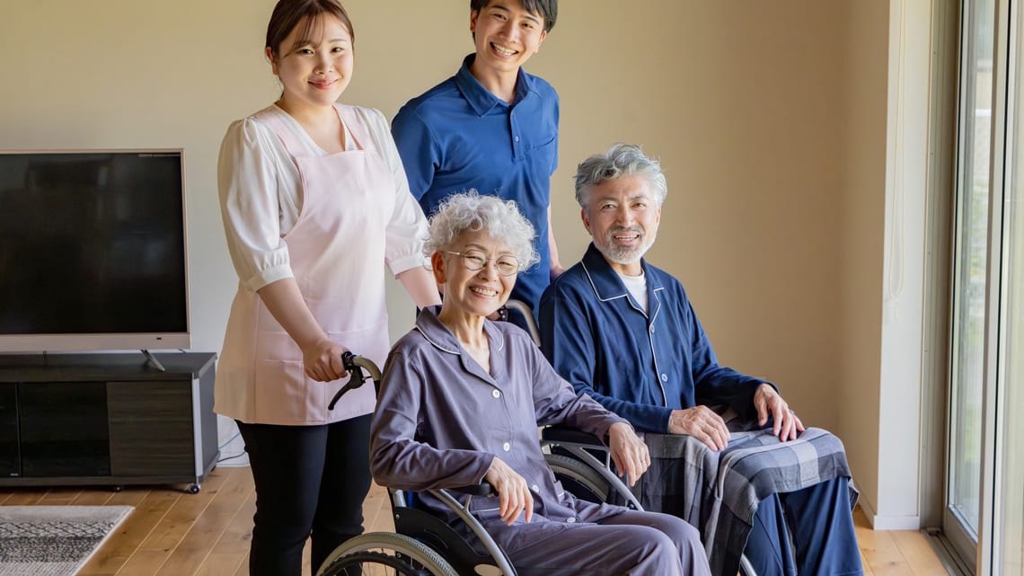 家庭的な部屋で、職員と一緒に過ごす高齢の方たちのイメージ