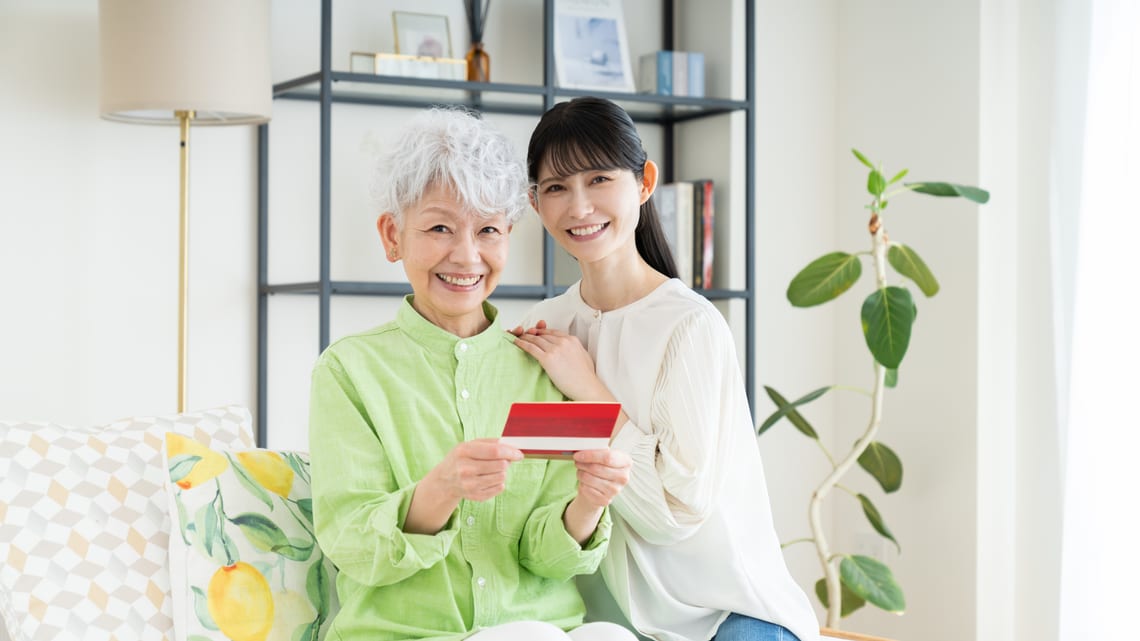 通帳を一緒に見るお母様と娘さんのイメージ